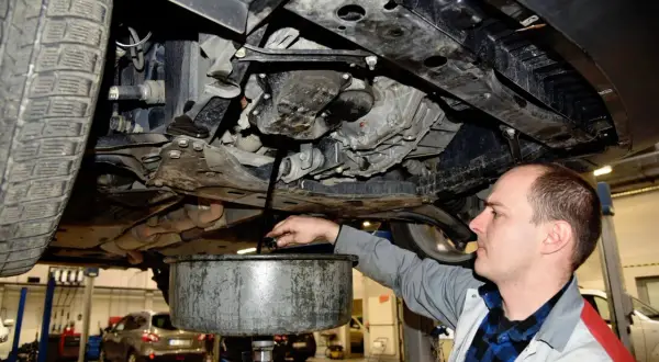Mechanik spuszcza zużyty olej z silnika. Regularna wymiana oleju co ile kilometrów zapewnia sprawne działanie auta.