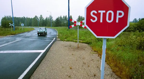 Znak stop przy przejeździe kolejowym. Kierowca powinien uważać, by nie dostać mandatu za niezatrzymanie się.