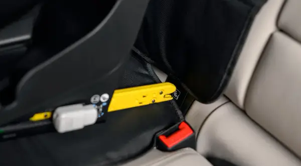 Żółty element mocujący fotelik samochodowy do systemu ISOFIX. Czy baza isofix pasuje do każdego fotelika? Sprawdź mocowanie.