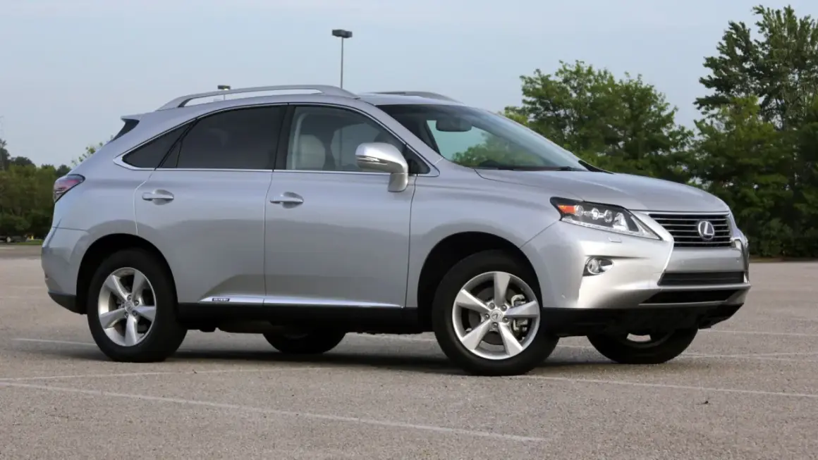Srebrny Lexus RX 450h, jeden z najmniej awaryjnych SUV-ów 10-letnich, zaparkowany na placu.