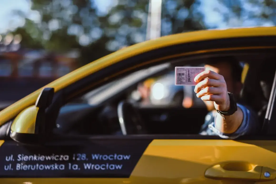 Kierowca pokazuje prawo jazdy, odpowiadając na pytanie, czy trzeba mieć prawo jazdy przy sobie podczas jazdy.