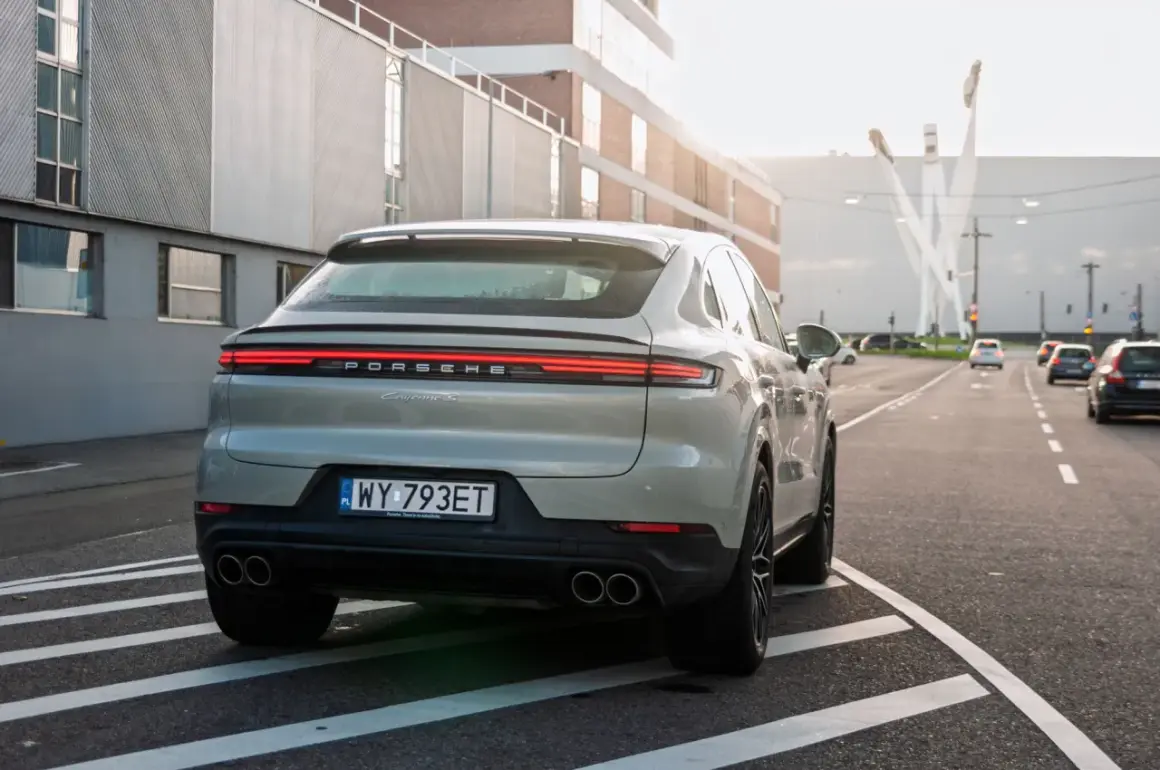 Szare Porsche Cayenne S z polskimi tablicami rejestracyjnymi na drodze. Porsche to niemiecka marka samochodów sportowych.