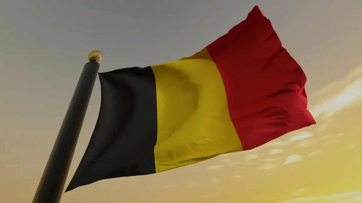 Flaga Belgii powiewa na wietrze. Uważaj na auta z belgii dokumenty, bo mogą być problematyczne.