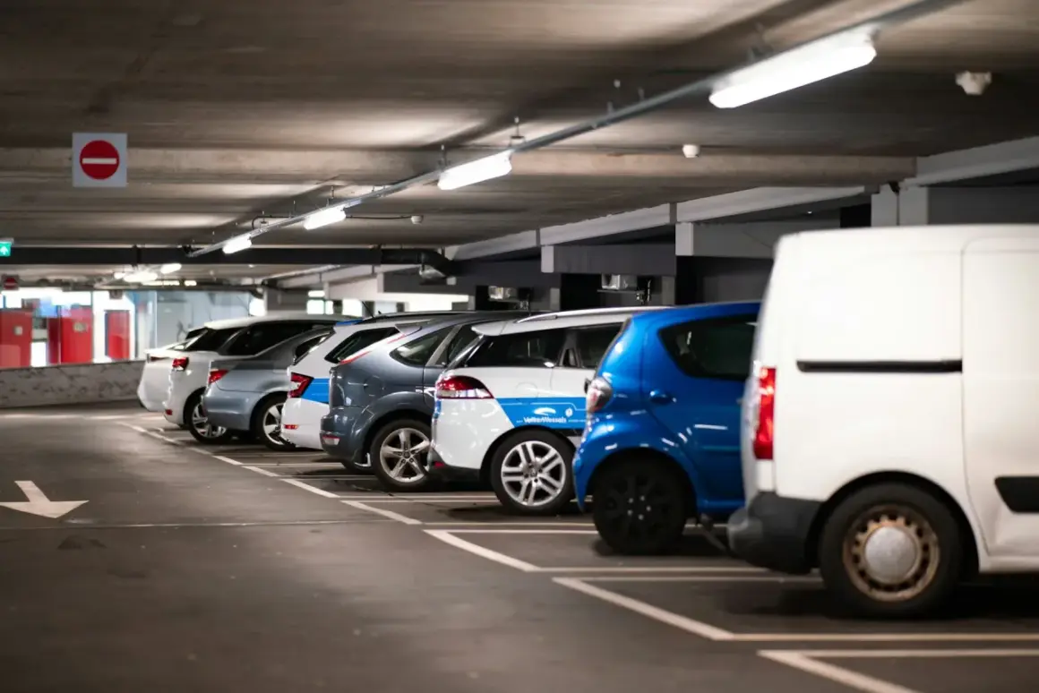 Rząd samochodów na parkingu podziemnym, gotowych do montażu czujników parkowania.