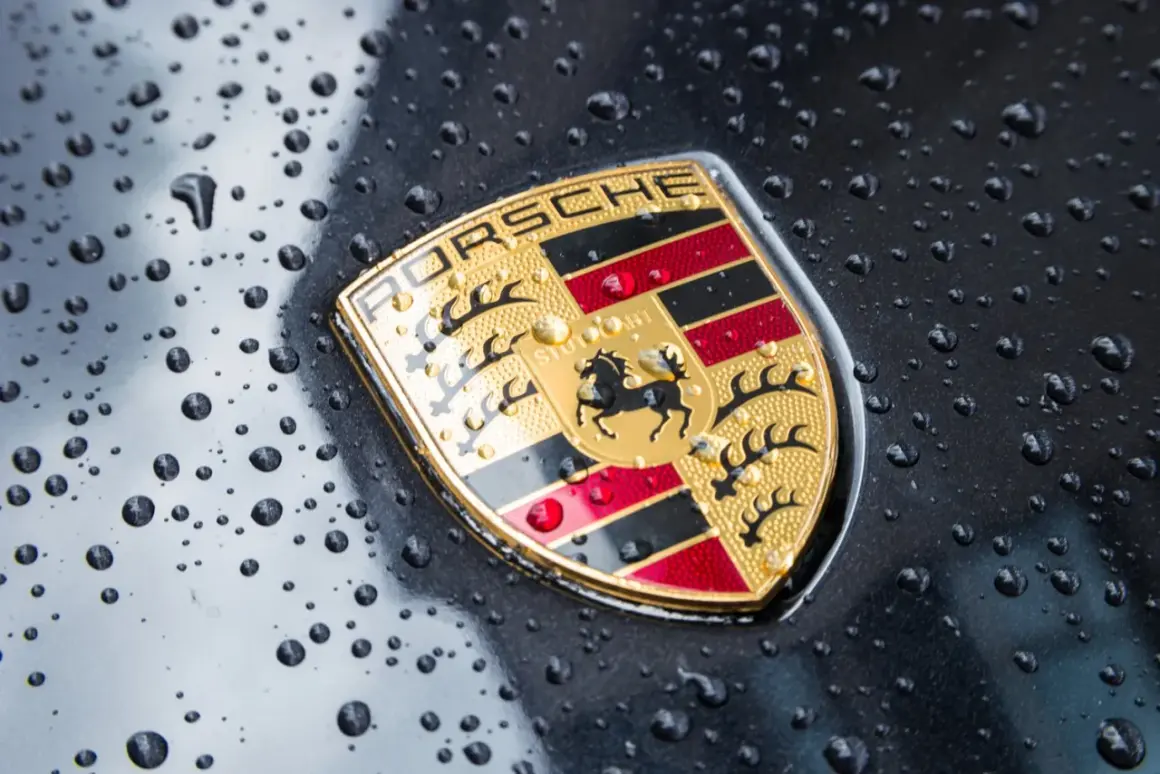 Znak Porsche, symbol luksusowych marek samochodów, lśni po deszczu.
