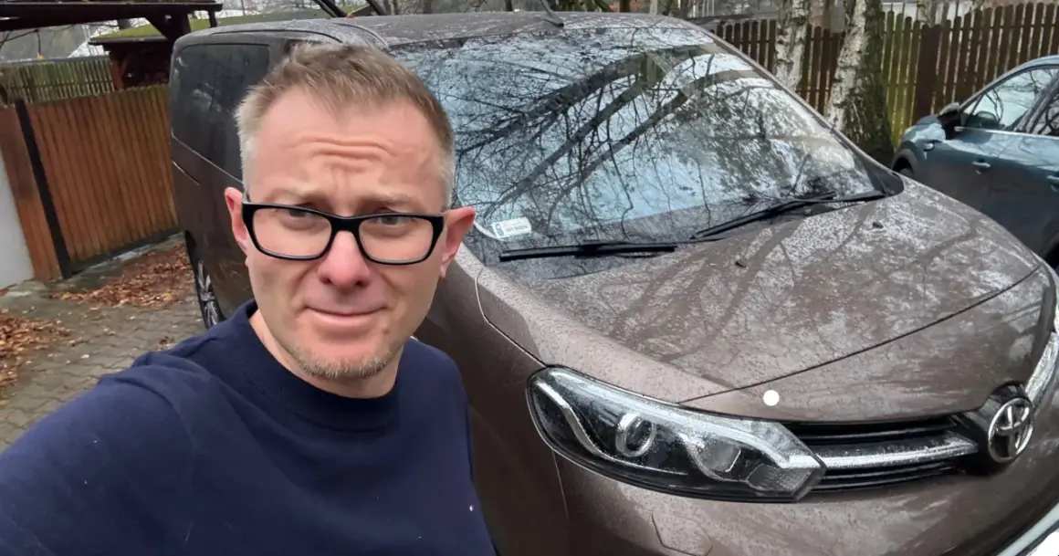 Mężczyzna w okularach przed brązowym autem, zastanawia się, jak szybko sprzedać auto.