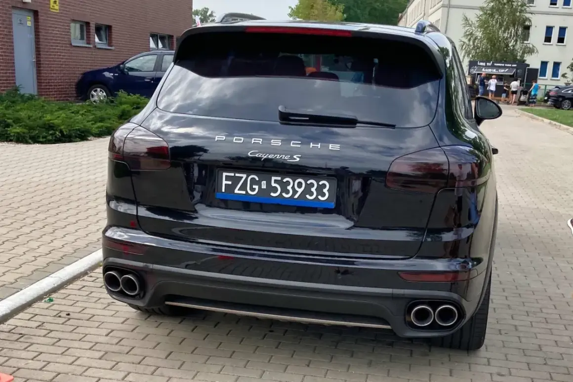 Czarne tablice rejestracyjne wykazują Porsche Cayenne S.