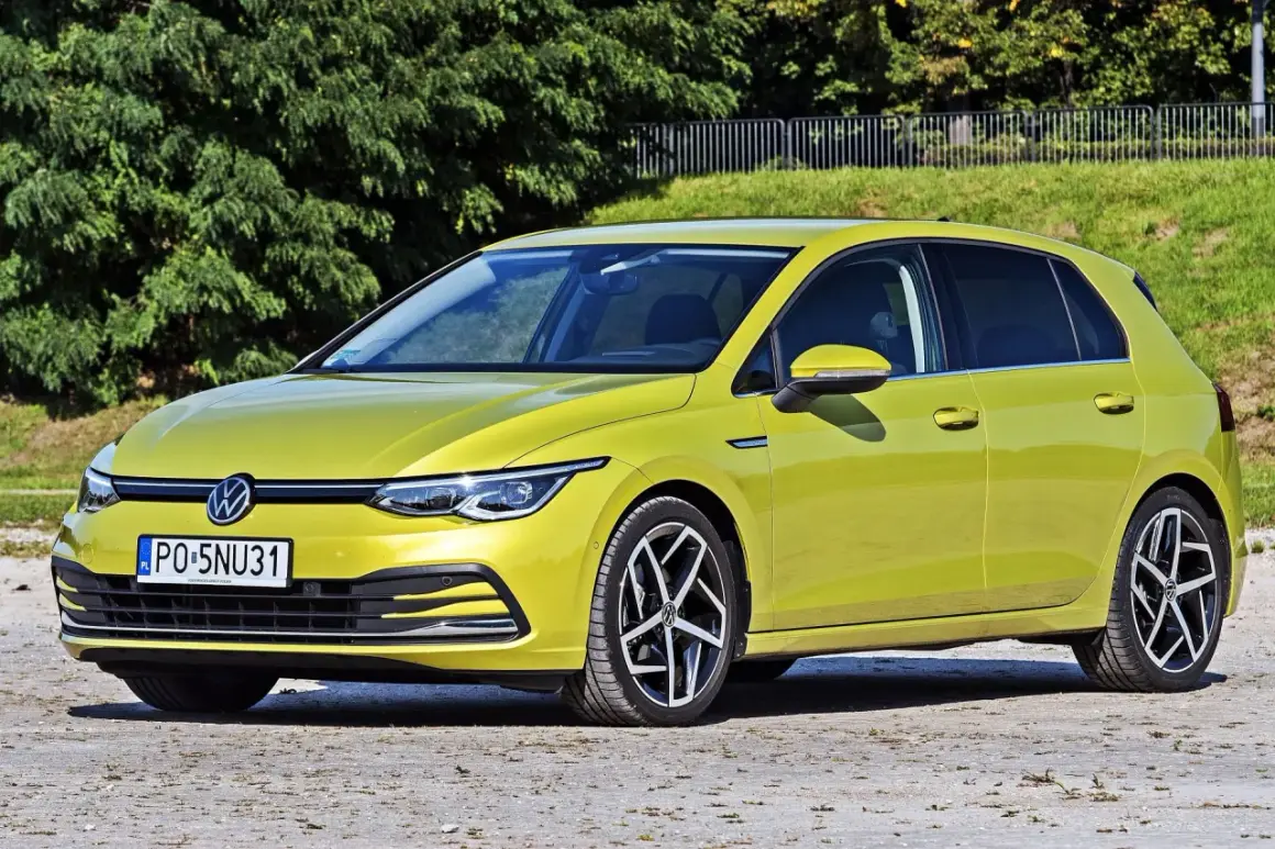Żółty Volkswagen Golf 8, jeden z wielu popularnych **volkswagen nazwy modeli**, zaparkowany na tle zieleni.