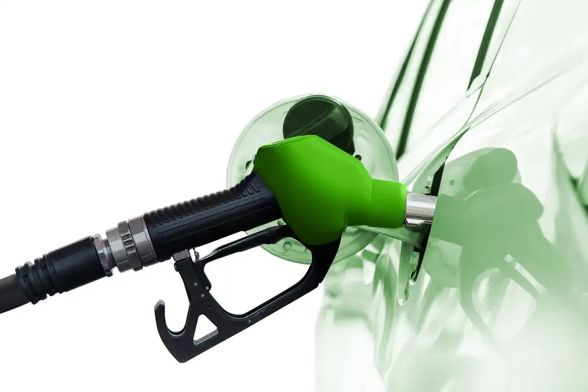Zielona dysza dystrybutora tankuje samochód. To paliwo diesel, które zasila silniki.
