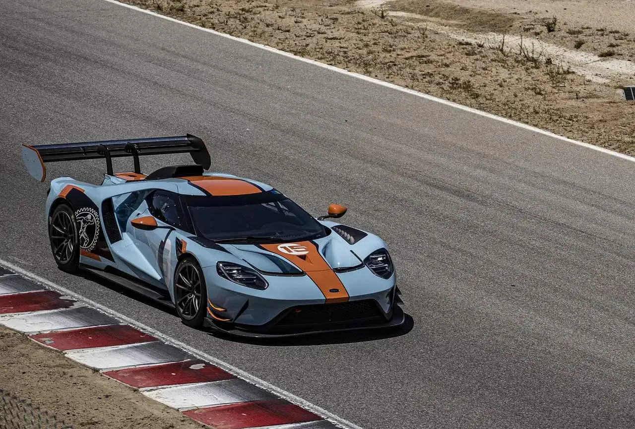 Niebiesko-pomarańczowy Ford GT na torze do jazdy samochodem, gotowy do wyścigu.
