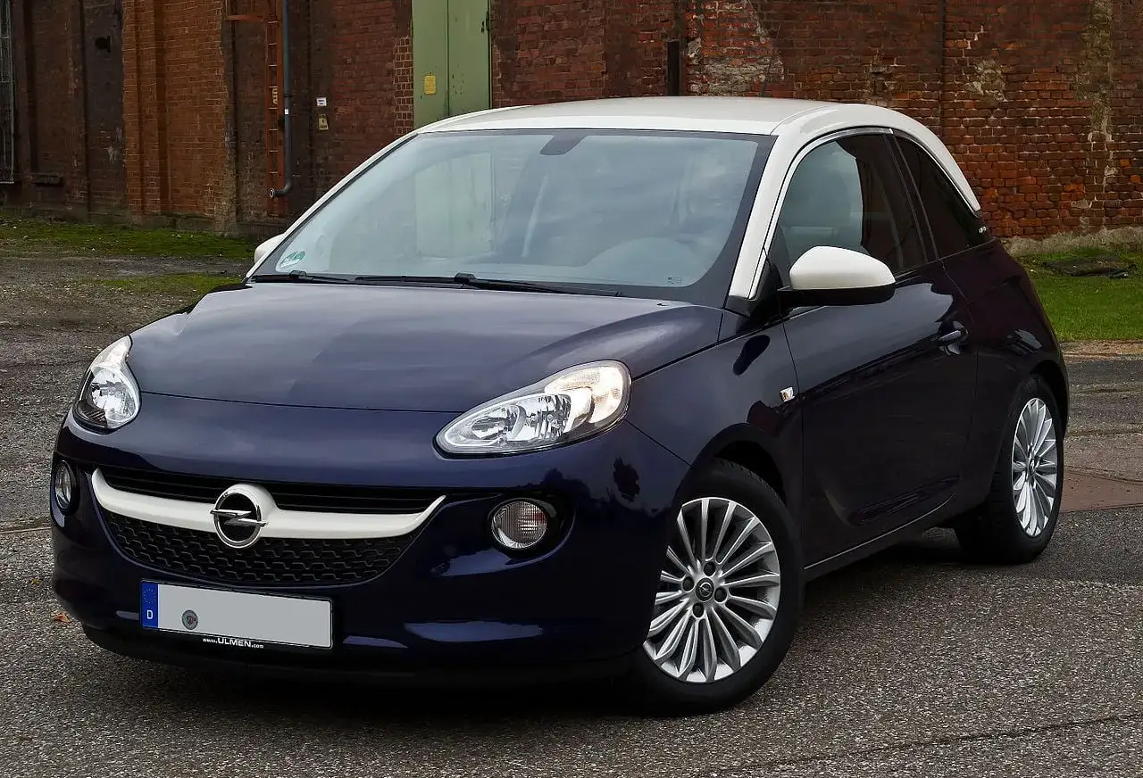 Granatowy Opel Adam z białym dachem, idealne pierwsze auto dla dziewczyny. Stylowy i kompaktowy, gotowy na miejskie przygody.