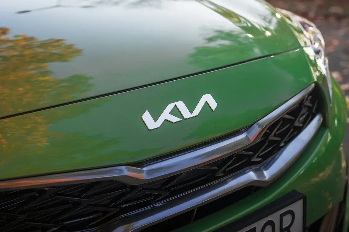 Nowe logo Kia na zielonej masce samochodu. Eleganckie, nowoczesne i gotowe na nowe wyzwania.
