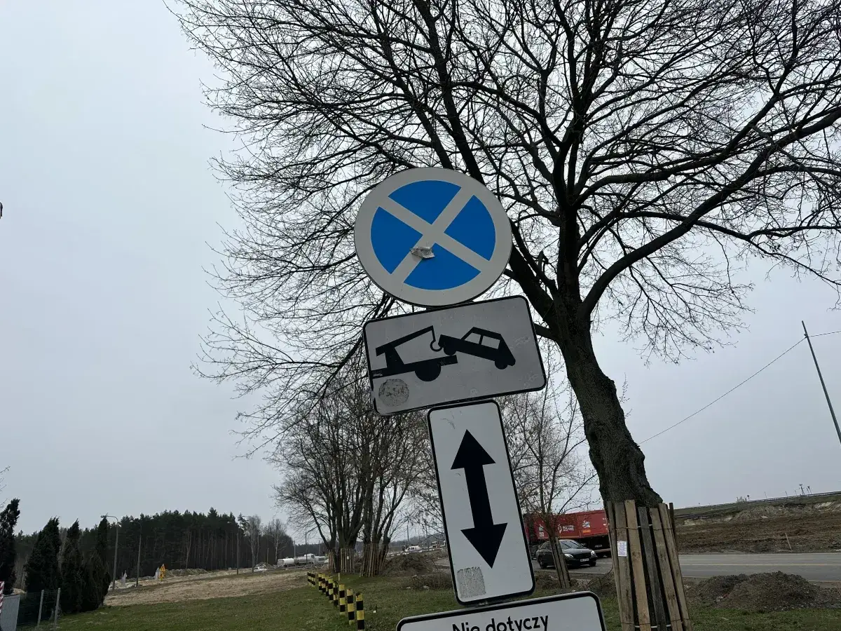 Znaki drogowe informują, gdzie nie można parkować. Widoczny zakaz zatrzymywania się i holowania pojazdów.