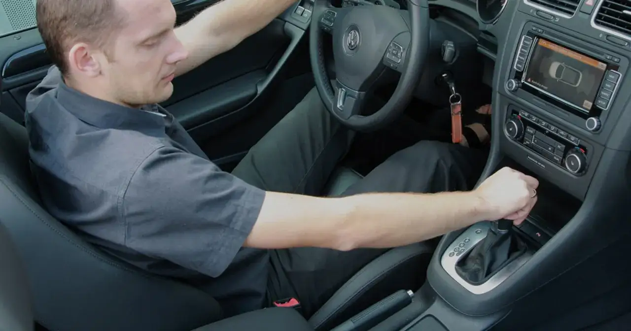 Mężczyzna w samochodzie z automatyczną skrzynią biegów DSG, pokazujący, jak jeździć automatem dsg.