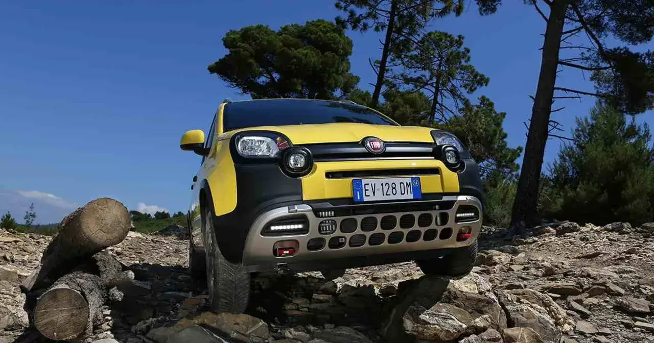 Żółty Fiat Panda Cross 4x4 pokonuje kamienisty teren.