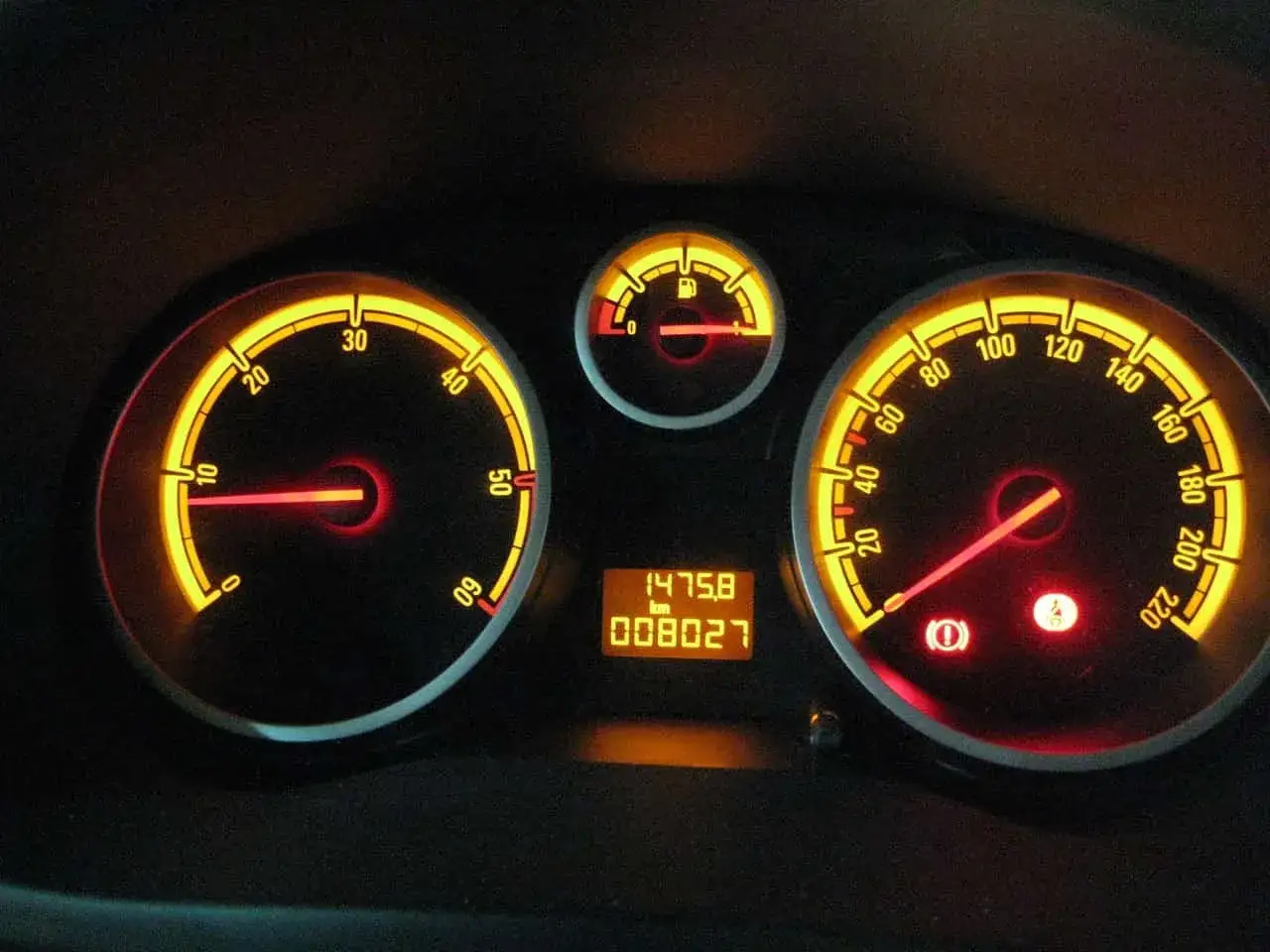 Podświetlony licznik samochodowy po wymianie licznika w samochodzie. Wskazuje prędkość 0 km/h i przebieg 80 027 km.