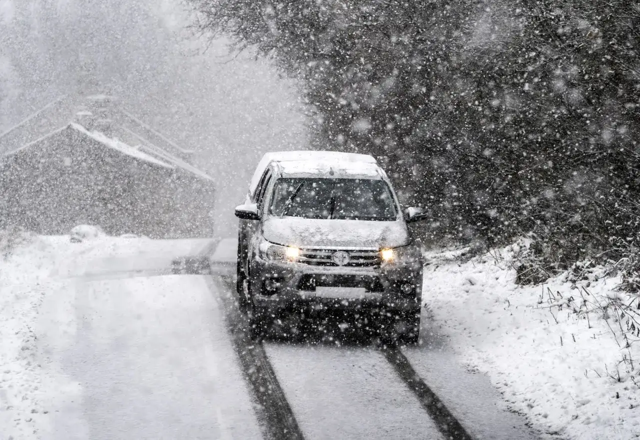 Samoch&oacute;d z napędem 4x4 pewnie jedzie przez śnieżycę. Wiele aut terenowych i SUV-&oacute;w ma stały napęd 4x4.