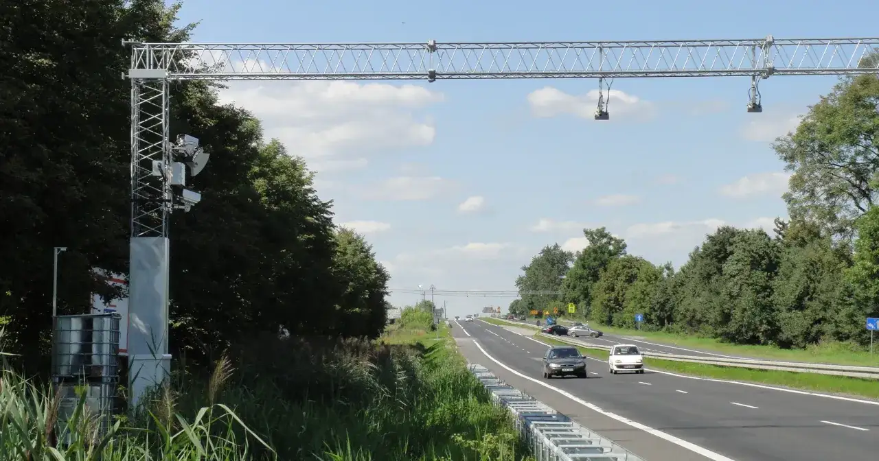 Nad autostradą A1 widać bramownicę z urządzeniami do odcinkowego pomiaru prędkości.