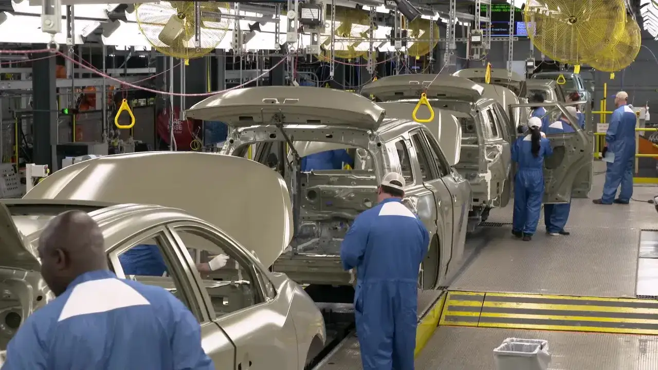 Pracownicy w fabryce składają karoserie samochodów Nissan. Zastanawiasz się, jaki kraj produkuje te auta?