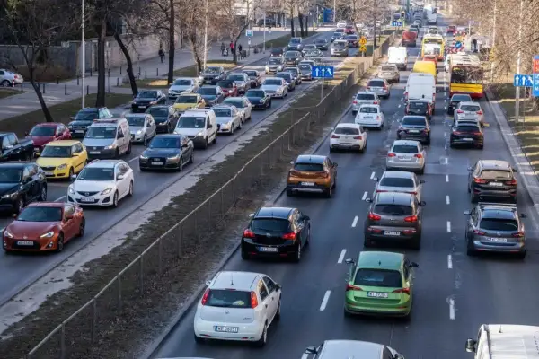 Korki na drodze, typowe dla najbardziej zakorkowanych miast w Polsce. Samochody stoją w długiej kolejce, tworząc obraz codziennych zmagań kierowców.