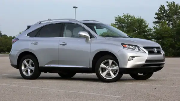 Srebrny Lexus RX 450h, jeden z najmniej awaryjnych SUV-ów 10-letnich, zaparkowany na placu.