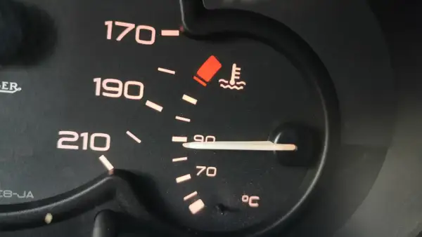 Czerwona kontrolka temperatury oleju świeci się, wskazując na przegrzewanie silnika. Wskaźnik pokazuje ponad 90°C.