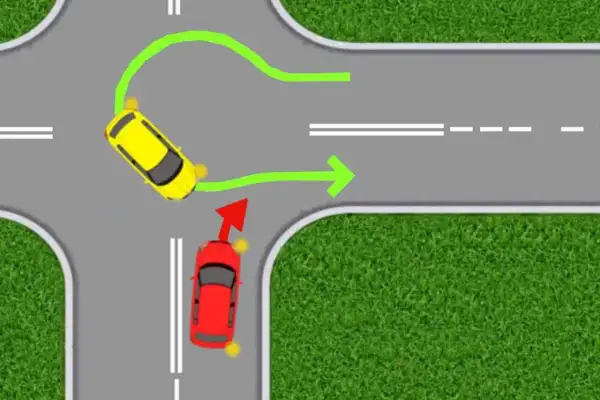 Żółty samochód wykonuje zawracanie na drodze dwujezdniowej, podczas gdy czerwony pojazd czeka na swój ruch.