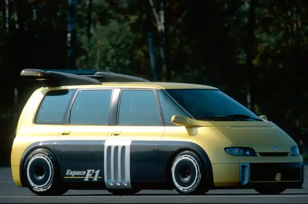 Żółto-szary Renault Espace F1 z masywnym spojlerem i sportowymi felgami, gotowy do wyścigu.