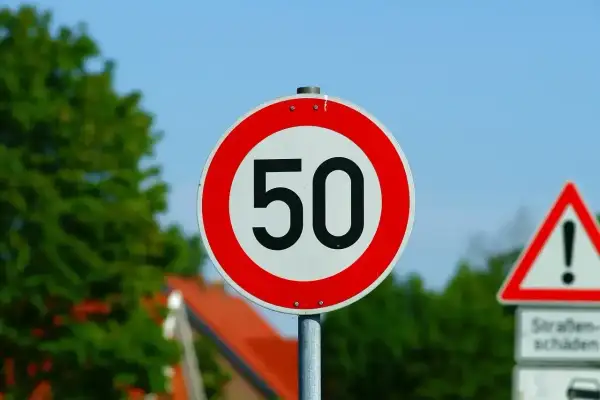 Znak ograniczenia prędkości do 50 km/h. Jaka prędkość w terenie zabudowanym jest dozwolona? Ten znak informuje kierowców.