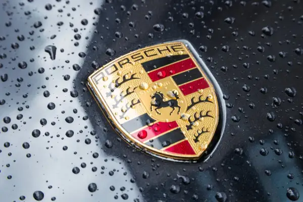 Znak Porsche, symbol luksusowych marek samochodów, lśni po deszczu.
