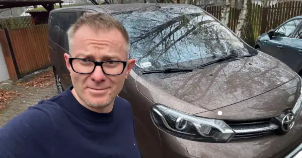 Mężczyzna w okularach przed brązowym autem, zastanawia się, jak szybko sprzedać auto.