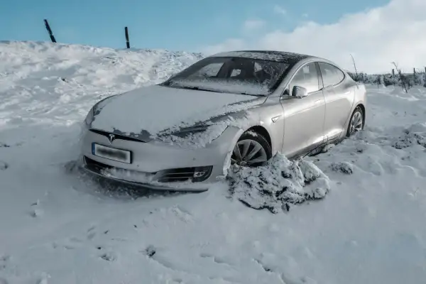 Srebrny Tesla utknął w zaspie śnieżnej. Czy to ogranicza zasięg samochodu elektrycznego w zimowych warunkach?