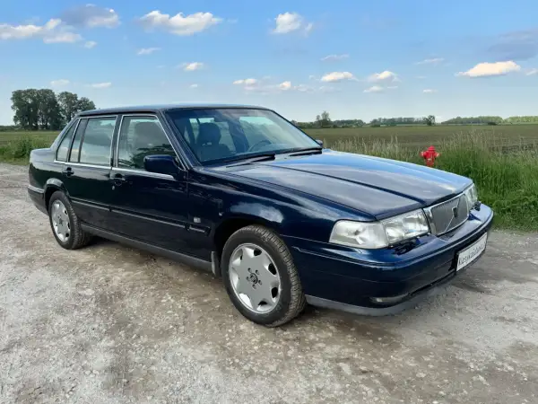 Granatowe Volvo S70, jeden z klasycznych modeli, stoi na szutrowej drodze.