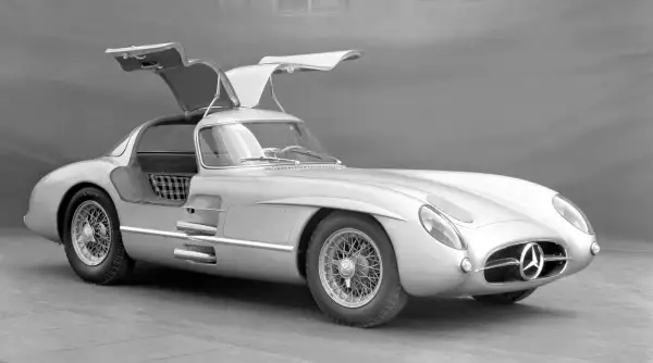 Srebrny Mercedes-Benz 300 SLR z otwieranymi do góry drzwiami, uznawany za najdroższe auto na świecie, prezentuje swoją legendarną sylwetkę.
