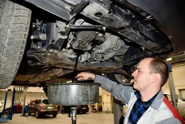 Mechanik spuszcza zużyty olej z silnika. Regularna wymiana oleju co ile kilometrów zapewnia sprawne działanie auta.
