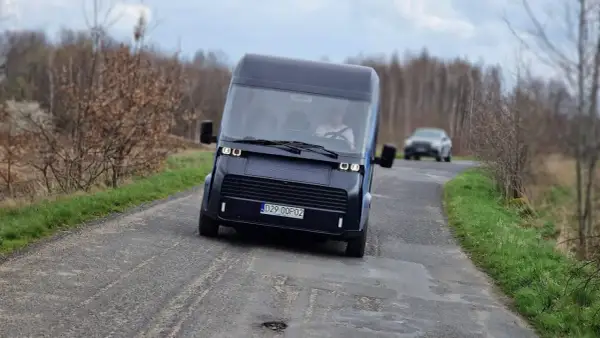 Nowoczesny polski samochód elektryczny na wiejskiej drodze.
